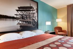 皮奥里亚皮奥里亚速8酒店的酒店客房设有一张床铺,墙上挂着一张大照片