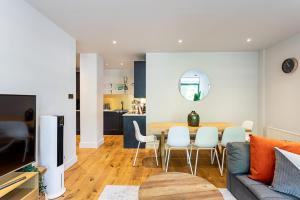a living room and kitchen with a table and chairs at Stunning Modern Apartment in the Heart of Holborn in London