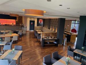 a restaurant with tables and chairs and a bar at AiREA Hotel in Büren