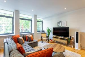 a living room with a couch and a flat screen tv at Stunning Modern Apartment in the Heart of Holborn in London