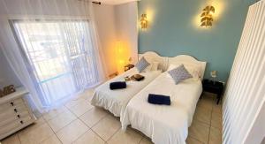 1 dormitorio con 2 camas con sábanas blancas y paredes azules en Blue Cristianos by W Tenerife, en Los Cristianos