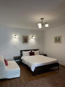 a bedroom with two beds and a couch at Pensiunea Central Sibiu in Sibiu