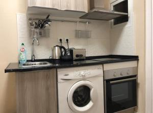 uma cozinha com uma máquina de lavar roupa e um lavatório em COMFORTABLE APARTMENT CLOSE TO BUNKERS DEL CARMEL! em Barcelona