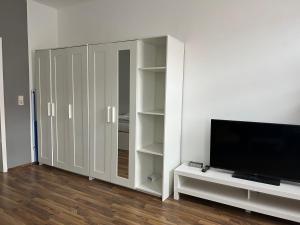 sala de estar con TV y armario blanco en Gemütliche Ferienwohnung mit gratis Netflix en Glauchau