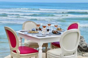 un tavolo con bicchieri da cibo e vino sulla spiaggia di Birkenhead House a Hermanus