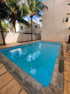 a large blue swimming pool next to a building at Le Nid Flic en Flac in Flic-en-Flac