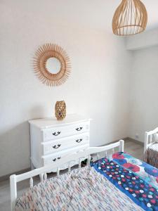 een slaapkamer met een bed, een dressoir en een spiegel bij Appartement sur Port - 78m2 Balcon in Saint-Gilles-Croix-de-Vie