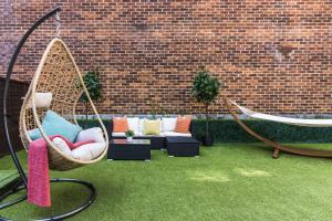 a patio with a hammock and chairs and a brick wall at Two Bedroom Apartment in Central London with Large Terrace in London