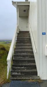 Un escalier mène à un bâtiment avec une porte. dans l'établissement 4 Bedroom Apartment - 20 Min Walk From City Centre - Nature, à Tórshavn