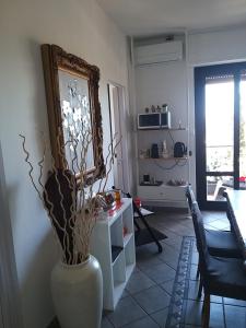 una sala de estar con un jarrón con flores. en Le stanze di Mina, en Cassina deʼ Pecchi