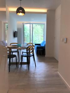 a dining room and living room with a table and chairs at Apartament 23 w Porto Łeba in Łeba