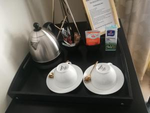a black tray with two white plates and a tea pot at The Houghton Villa in Johannesburg