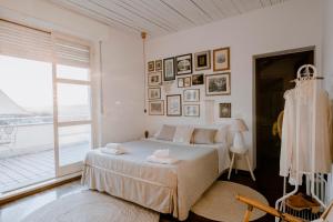 アルバにある"Villa Alba" stay with the Sommsの白いベッドルーム(ベッド1台、大きな窓付)