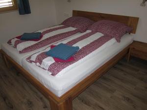 a bed with red and blue pillows on it at Ferienhaus Friedle in Leogang