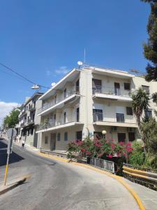 Cozy,fully equipped historic Athens apartment very close to Acropolis في أثينا: مبنى ابيض على جانب شارع