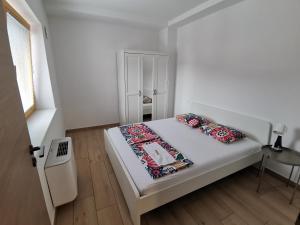 a small white bedroom with a bed and a window at PUBYLAND ROOMS & APARTMENTS in Rogatec