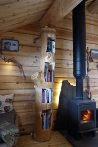 ein Zimmer mit einem Holzofen und Büchern in der Unterkunft Bardu Huskylodge 