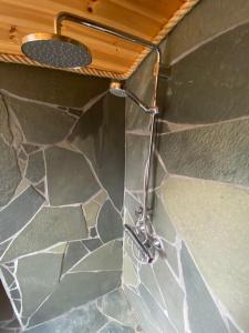 um chuveiro na casa de banho com uma parede de pedra em Bardu Huskylodge 