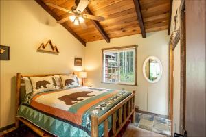 1 dormitorio con 1 cama y ventilador de techo en Elk Meadows Cottage, en Packwood