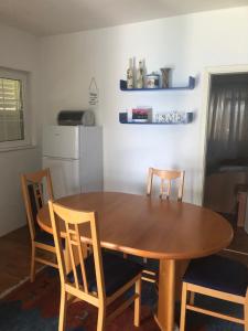 uma cozinha com uma mesa de madeira e cadeiras em Apartment Deep Blue Sea em Vantacići