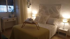 dos animales de peluche sentados en una cama en un dormitorio en Apartamento Los Padrinos, en Córdoba