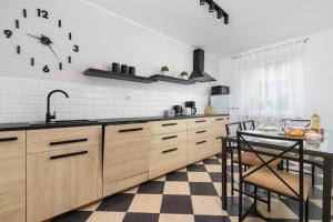 cocina con armarios de madera y suelo a cuadros en Pleasant Apartment with Terrace Cracow by Renters, en Cracovia