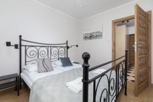 1 dormitorio con 1 cama con cabecero de hierro forjado en Pleasant Apartment with Terrace Cracow by Renters, en Cracovia