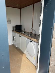 uma cozinha com um lavatório e uma máquina de lavar roupa em Boujie Barn- Stable em Waterfall