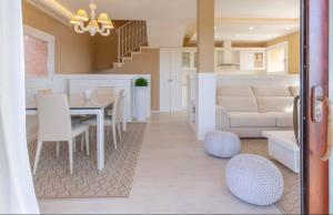 a dining room and living room with a table and chairs at Torretta con vista mozzafiato in Chia