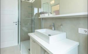 a bathroom with a white sink and a shower at Torretta con vista mozzafiato in Chia +6 photos