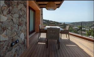 a wooden deck with a table and chairs on a balcony at Torretta con vista mozzafiato in Chia