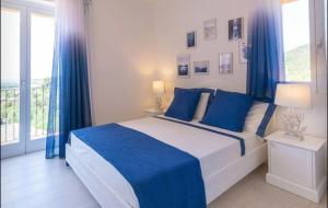 a bedroom with a large bed with blue curtains at Torretta con vista mozzafiato in Chia