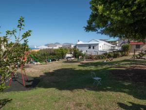 a park with a chair in the grass at Behr Road Apartment with sea view patio in Cape Town