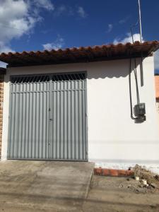 a white building with a large metal garage door at Rosana House Bem estar em Barreirinhas Ideal para 5 pessoas in Barreirinhas