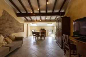 a living room with a couch and a tv and a table at Grace apartment - Smart Holiday in Mantova