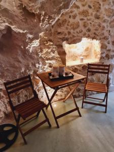 a wooden table and two chairs in a cave at Anassa Cave by Estia in Heraklio Town