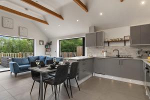 Willow Cottage في تينبي: مطبخ وغرفة معيشة مع طاولة وكراسي