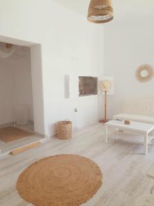 a living room with a rug on a wooden floor at Salty Caves Apartments Milos in Tripiti