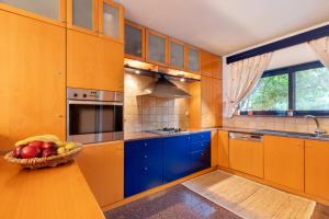a kitchen with blue cabinets and a bowl of fruit on a table at Rhodes Sunrise Maisonette in Koskinou