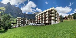 un edificio en una colina junto a un campo verde en Ferienwohnung Valere B - it's magic gmbh, en Leukerbad