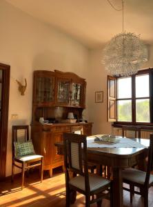 une salle à manger avec une table, des chaises et un lustre dans l'établissement La luna e i falò, à Arezzo