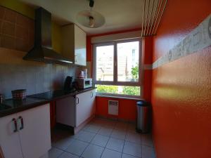 une cuisine aux murs rouges et une fenêtre dans l'établissement Park Line garden, à Strasbourg
