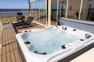 a bath tub on a deck with a view of the ocean at Marina Resort A7 in Kalajoki +1 photo