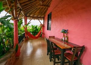 a dining room with a pink wall and a wooden table at Hotel Campestre Solar De La Luna in Armenia