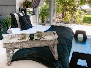 a wicker coffee table with two cups on it at Villa Palmera in Mossel Bay