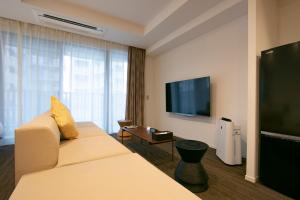 a hotel room with a couch and a flat screen tv at Minn Asakusa in Tokyo