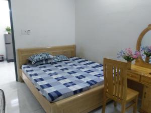 a bedroom with a bed and a table and a desk at Thao Nguyen Homestay in Thôn Mỹ Phước