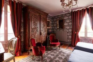 Un dormitorio con sillas rojas y un gran armario de madera. en Manoir des Lions de Tourgéville, en Deauville