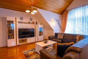 a living room with a couch and a tv at Ferienwohnung Schötz in Moosbach