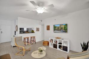 a living room with a ceiling fan and chairs at Yacht Club Newly renovated parking included in Aventura +33 photos